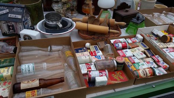 A table of boxed household items at auction